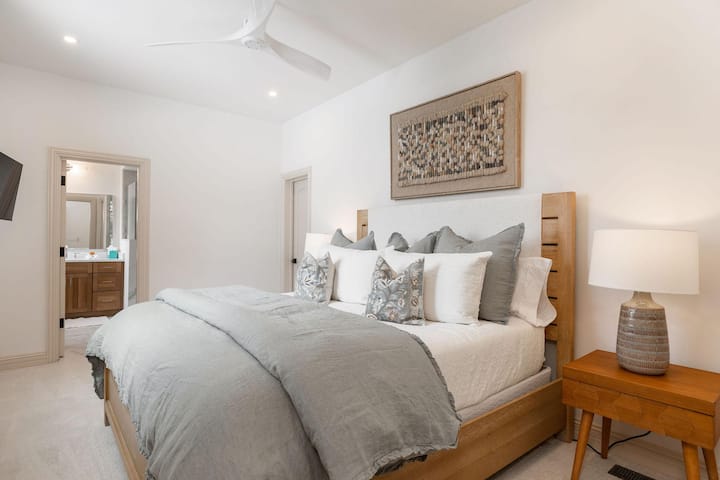 La suite principale située au rez-de-chaussée offre un havre de paix avec sa propre salle de bain attenante et un bureau attenant.