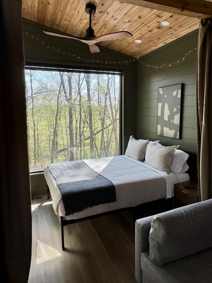 Cama queen acogedora con vista