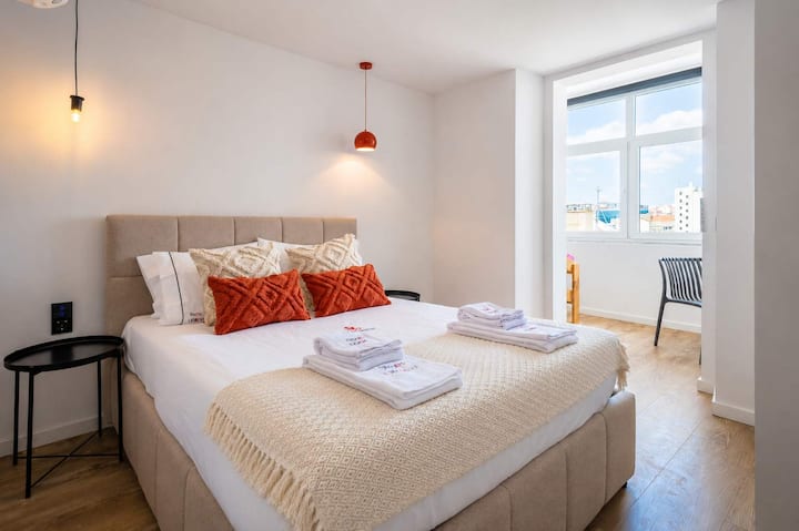 23 · Dormitorio doble con vista a la ciudad y luz natural · StayInLisbon
