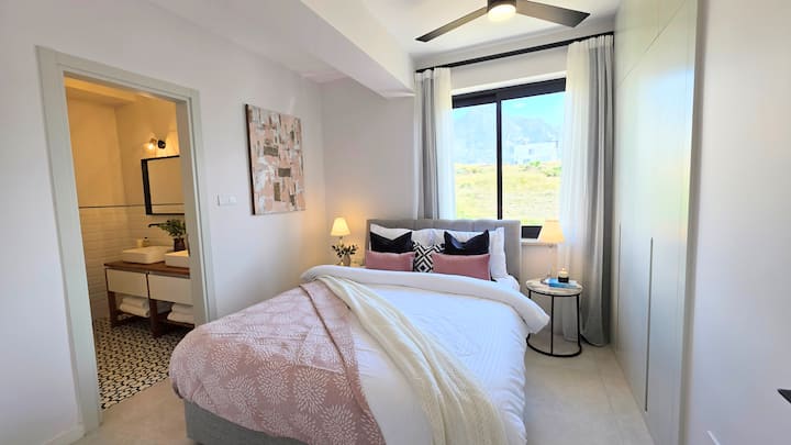 Détendez-vous dans cette chambre élégante avec un très grand lit et une vue sur la montagne. La seule salle de bains privée de la villa, avec une baignoire luxueuse et deux lavabos. Une retraite calme et privée conçue pour le confort, la détente et le repos après une belle journée.