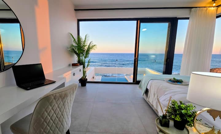 Réveillez-vous avec une vue panoramique imprenable sur la mer dans cette chambre luxueuse avec une salle de bains privée et un espace de travail dédié. Détendez-vous en toute sérénité en admirant le bleu infini de la Méditerranée depuis le confort de votre lit.