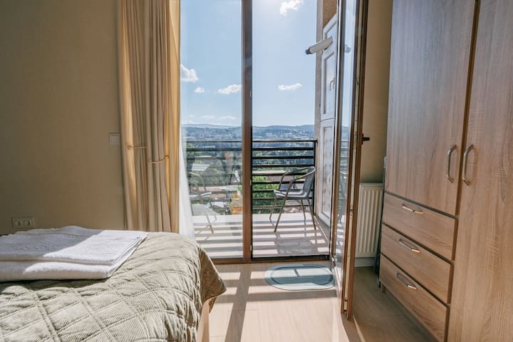 Wake up to panoramic views of Tbilisi. The bedroom opens directly onto its own private balcony.