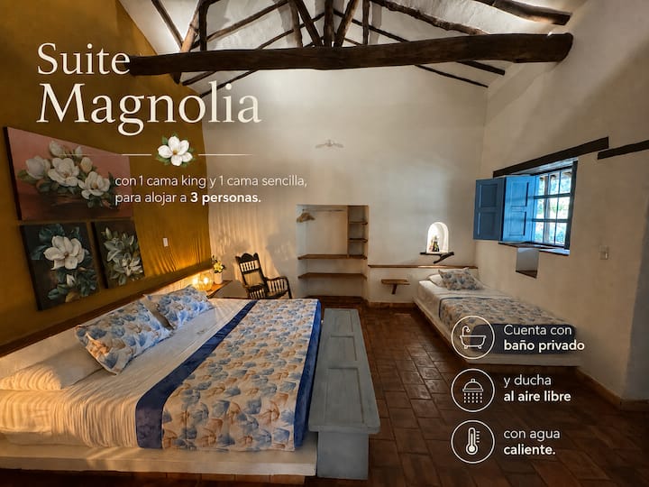 Suite Magnolia pouvant accueillir 3 personnes, 1 lit King Size, 1 lit simple, une armoire encastrée et une salle de bain privée avec douche extérieure et eau chaude.
