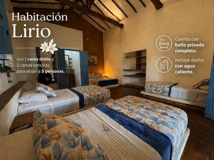 Chambre Lirio pouvant accueillir 5 personnes, 1 lit double, 3 lits simples, une armoire encastrée et une salle de bain privée complète avec eau chaude.