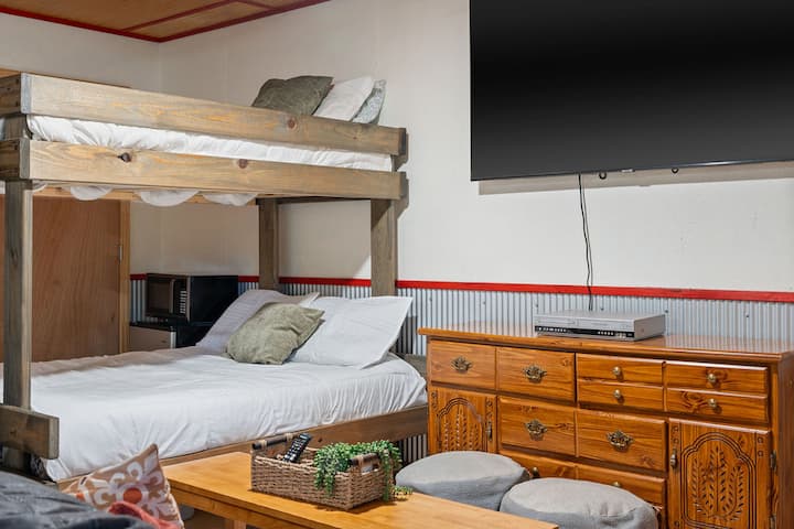 Acogedor rincón rústico con literas, TV y espacio para dormir apto para familias