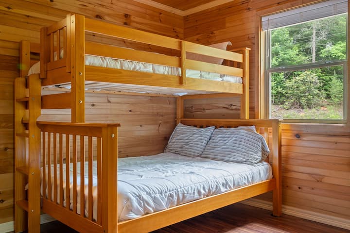 Acogedora habitación con literas y paneles de madera con vista al bosque, perfecta para familias