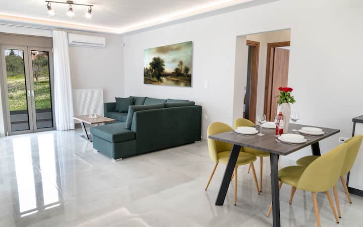 Sala bastante espaciosa, con un televisor de 43 pulgadas, un sofá de dos plazas, una mesa de centro, una ventana con vista y una hermosa decoración.