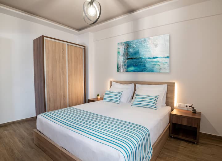 Recámara con una (1) cama king (1.90 × 2.00 m), tomacorrientes, cabecera, almohadas, clóset, área de trabajo, sillas, tabla de planchar, caja fuerte y ventana con vista