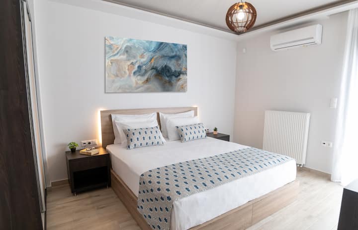 Recámara con una (1) cama king (1.90 × 2.00 m), tomacorrientes, cabecera, almohadas, clóset, área de trabajo, tabla de planchar, caja fuerte y acceso al balcón con vista