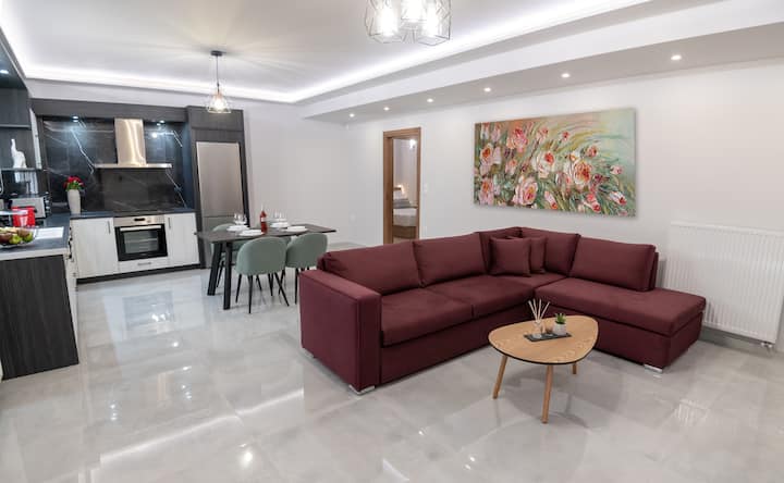 Sala bastante espaciosa, con un televisor de 43 pulgadas, un sofá de dos plazas, una mesa de centro, una ventana con vista y una hermosa decoración.