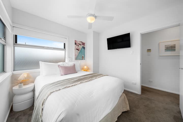The third bedroom offers a queen bed, a private TV and a relaxed atmosphere that makes winding down with a movie after beachside dinners feel wonderfully easy.