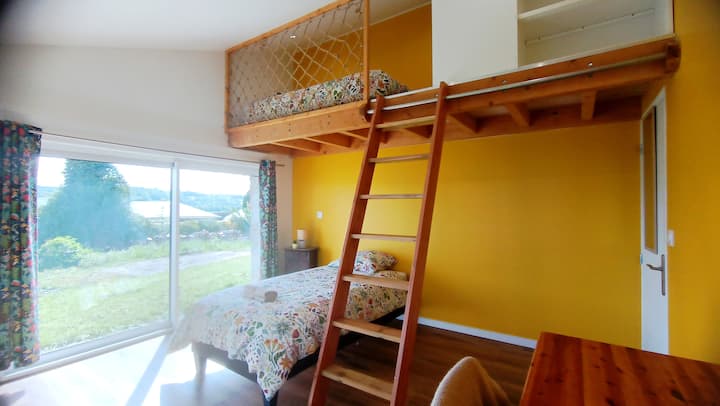 Una habitación luminosa y atípica, que combina una cama individual en el suelo y una zona de descanso en el entresuelo.