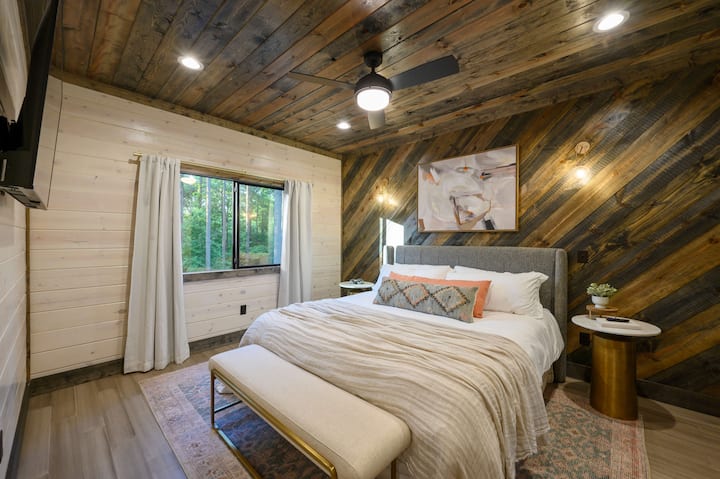 Boutique bedroom design with a unique diagonal wood slat wall and mid-century furniture.