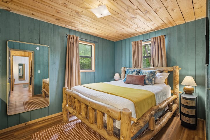 Hermoso dormitorio en la planta baja diseñado con relajantes tonos verdes que aportan un ambiente acogedor e inspirado en la naturaleza en el interior. Ofrece una cama tamaño queen para dos y un espacio de trabajo privado perfecto para relajarse o trabajar.