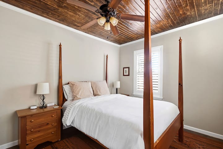 Charming bedroom with four-poster bed and rich wood ceiling accents