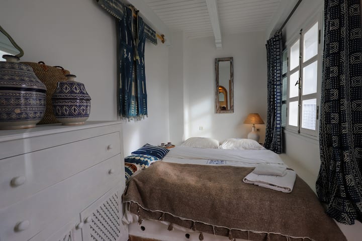 Chambre lumineuse et cosy avec décoration locale, linge de qualité et ambiance paisible pour un séjour tout confort.