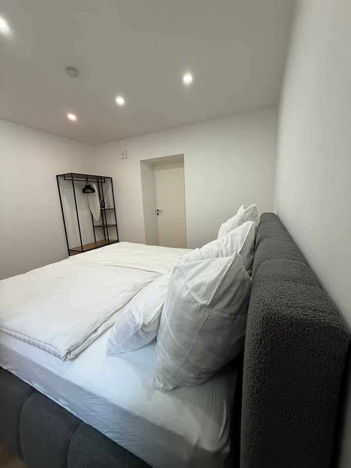 Dormitorio con cama tamaño king, sábanas limpiadas profesionalmente, opciones de cortinas opacas, armario, perchas, plancha y tabla de planchar.