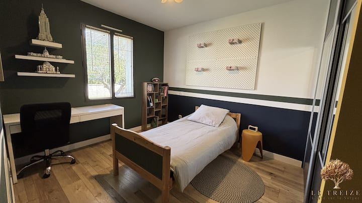 Quarto 3 com cama de solteiro, ventilador de teto, guarda-roupas e mesa de trabalho