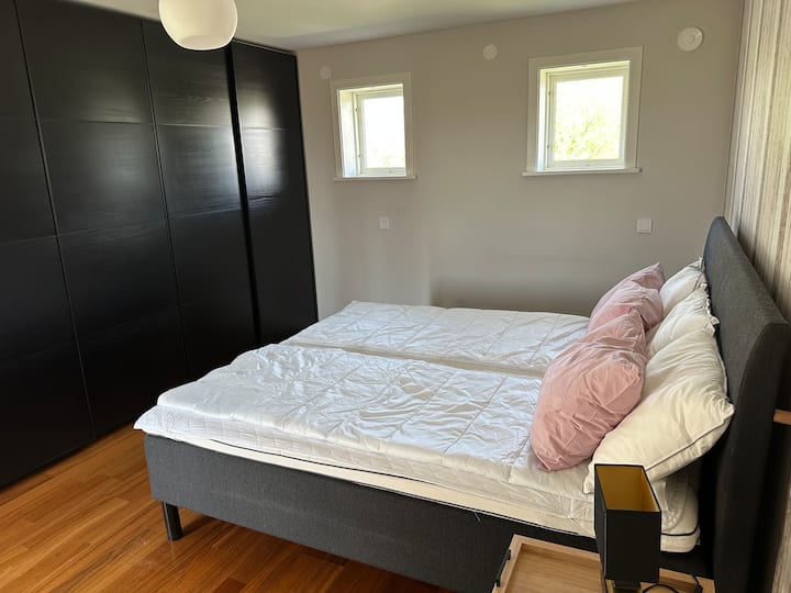 Stora sovrummet på bottenplan med dubbelsäng (bredd 180 cm) och stora garderober