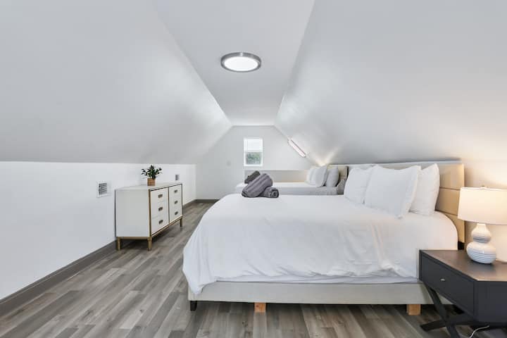Upstairs bedroom with a queen bed and a dresser under the angled roofline.