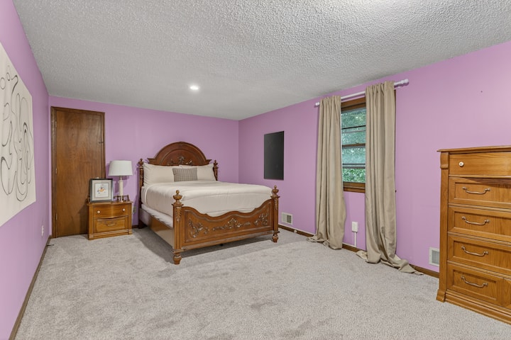 Spacious bedroom retreat with soft tones, plush carpeting, and plenty of room to relax in comfort.