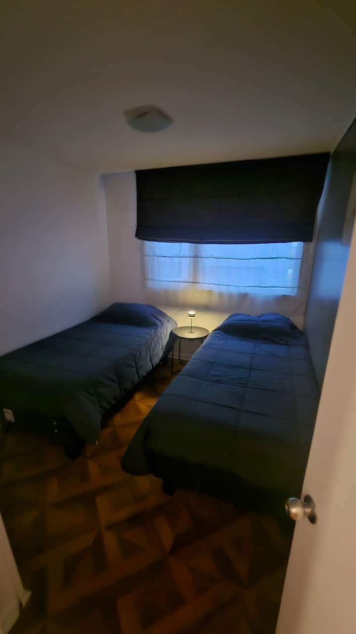segunda habitación con dos camas individuales, lampara de noche luz cálida, closet y cortinas black out para un mejor descanso.