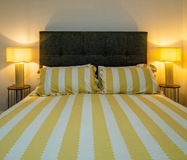 Preciosa y cómoda cama tamaño king en el dormitorio 1; esta habitación también tiene un baño privado con inodoro, lavabo y tina.