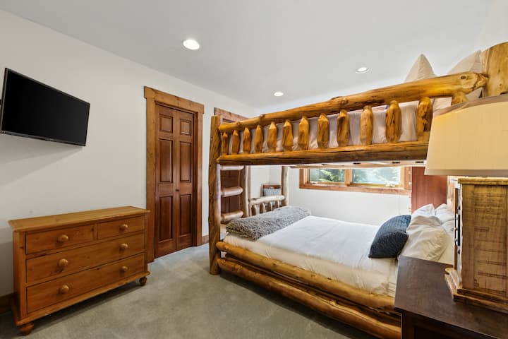 Chambre d'amis 2 à l'étage supérieur avec lits superposés « queen-over-queen », télévision, grande fenêtre et salle de bain attenante avec douche.