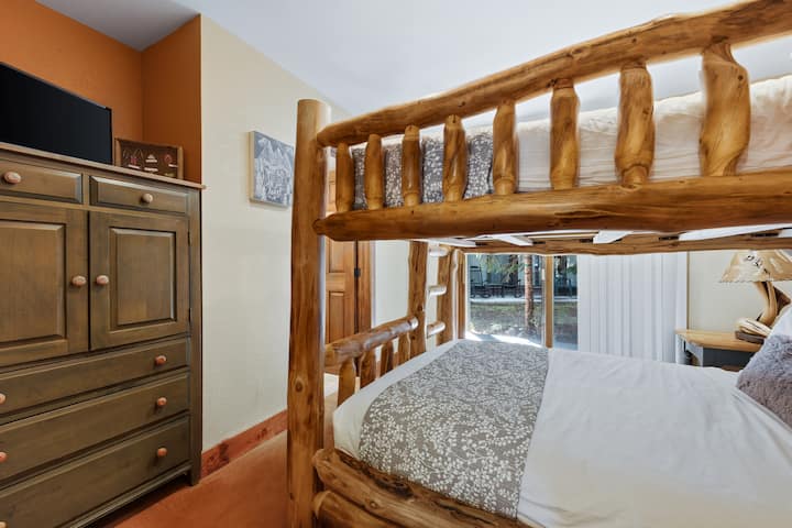 Chambre d'amis 3 au niveau inférieur avec lits superposés « queen-over-queen », porte coulissante donnant accès au patio, télévision et salle de bain attenante avec douche.