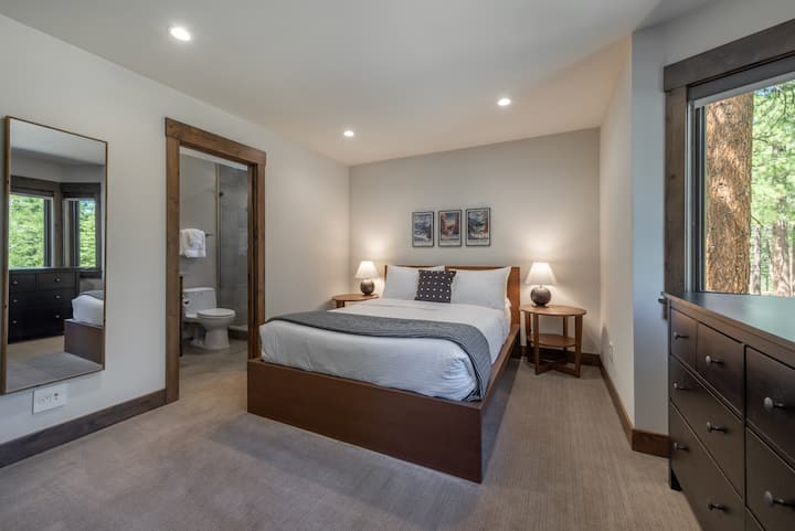 Este dormitorio con cama tamaño queen en el primer piso tiene su propio baño privado y hermosas vistas al bosque.