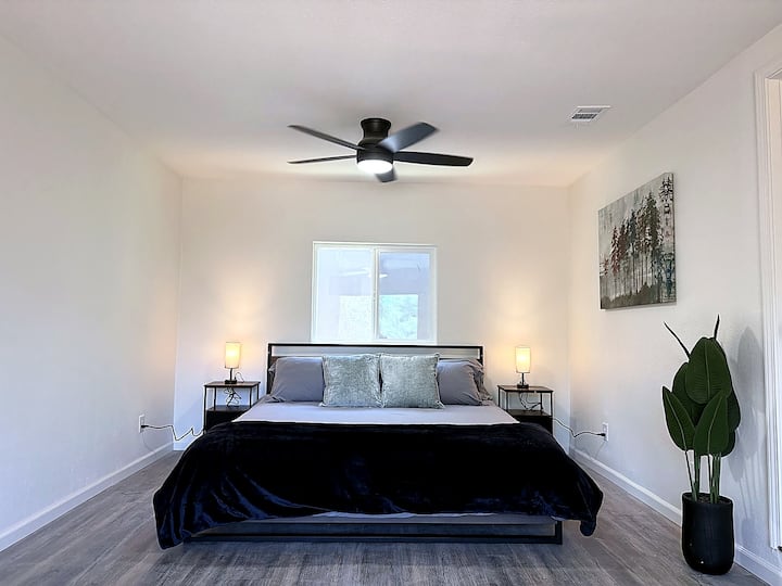 Amplia suite principal con cama tamaño king, iluminación acogedora y acceso a un balcón privado a través de una puerta corrediza de vidrio, perfecta para disfrutar de un tranquilo café por la mañana o relajarse después de un día de aventuras.