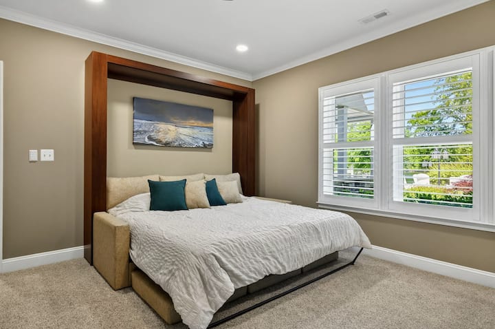 Habitación con literas: cama plegable tamaño king desplegada con sábanas frescas y un estampado frente al lago arriba, el lado para adultos de la habitación favorita de los niños.
