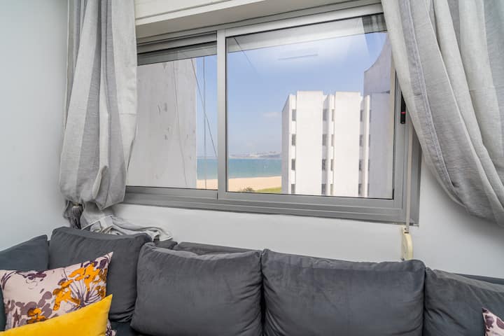 dnevni boravak s televizorom i prozorom koji gleda na plažu