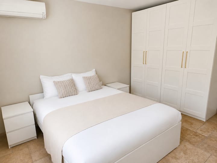 Una habitación grande que contiene:
- una cama de 160x200 con cama nido y colchón de 80x200.
- dos armarios con espacio de almacenamiento.
- dos mesas de cabecera.
