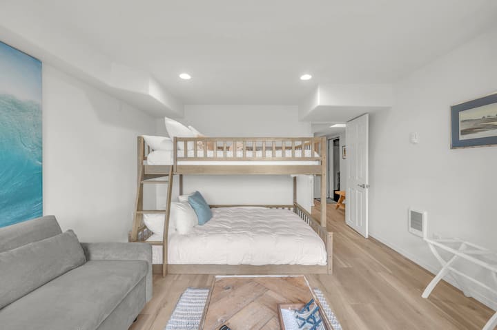 Tu acogedora habitación con temática de playa cuenta con una litera con un colchón matrimonial en la parte inferior, perfecta para familias, además de un cómodo sofá y un espacio amplio e iluminado por el sol para la máxima relajación.