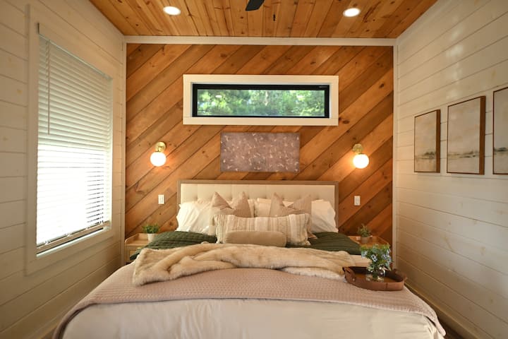 Misty Pines was designed as a peaceful retreat, with warm wood accents, layered textures, and a plush king bed.