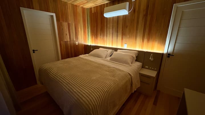 Suite para o casal, com ar condicionado, cortinas blackout, colchão King Size Simmons e roupeiro. Porta janela com acesso a sacada frontal e a bela vista das montanhas e do sol nascendo.