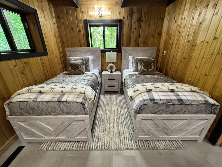 You can find this adorable bedroom in the lower level of Timberhawk! We call it the Deer Room! Comfy bedding, pillows, and blankets on these two twin beds make the perfect up north sleeping space for two!