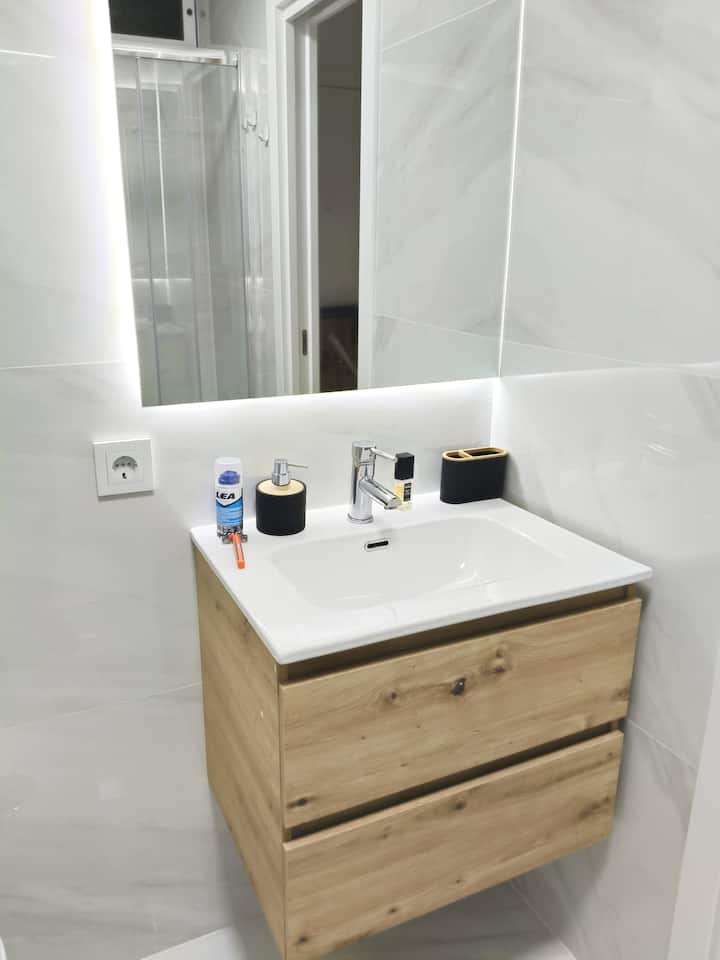 Lavabo moderno con espejo retroiluminado.