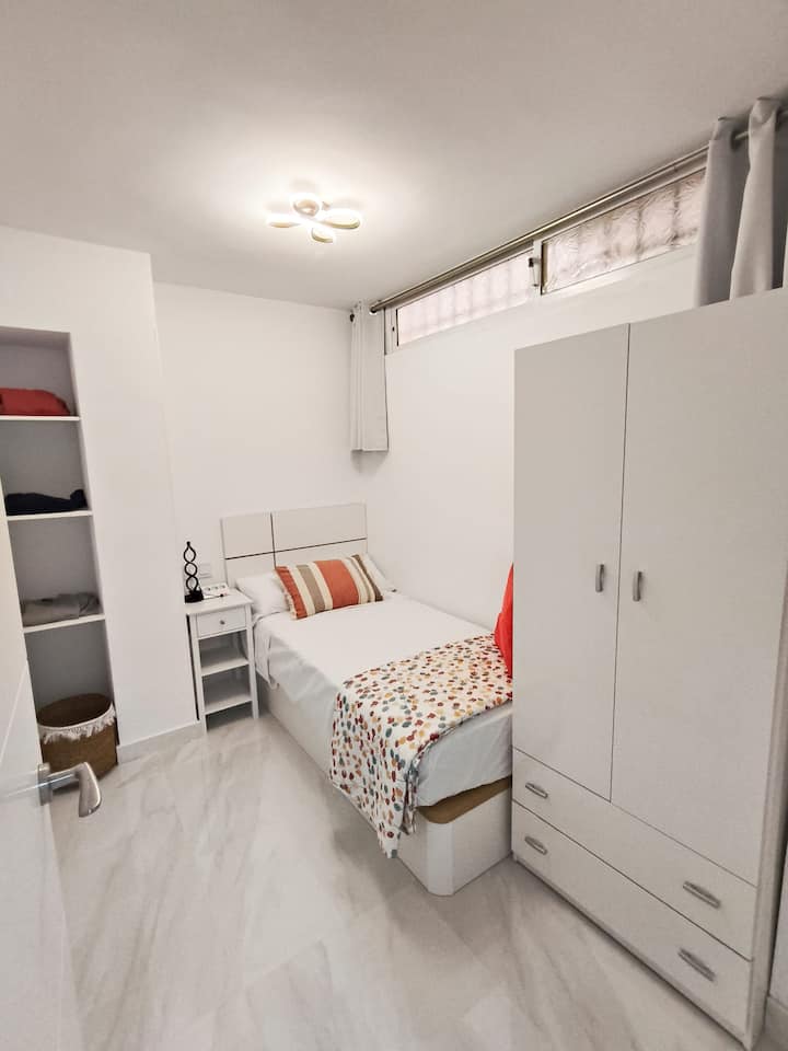 Dormitorio 2 con cama individual y estanterías: acogedor y funcional.