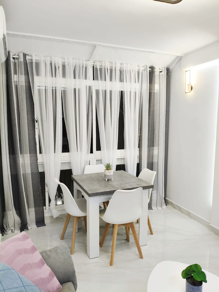 Rincón de comedor con cortinas y mucha claridad.