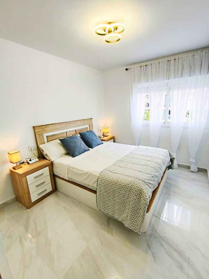 Dormitorio 1 con mesillas y lámparas: ambiente cálido de noche.