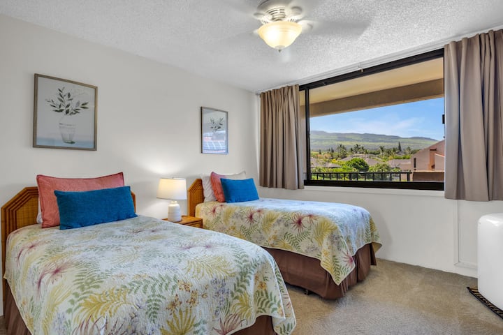 Despiértate con la suave brisa de la isla y las amplias vistas a la montaña desde tu acogedor refugio con camas individuales, donde la ropa de cama con estampado tropical y el tranquilo paisaje del jardín crean tu escapada perfecta a Maui.