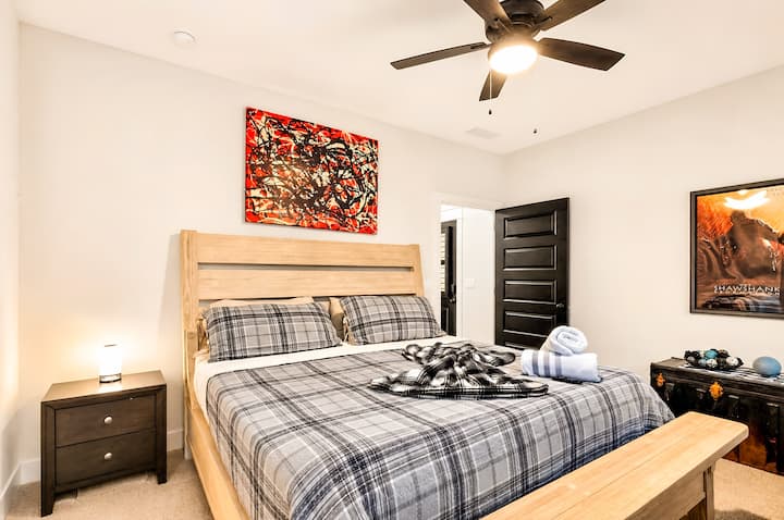 Acogedora habitación moderna con ropa de cama a cuadros, arte atrevido y detalles pensados para los huéspedes