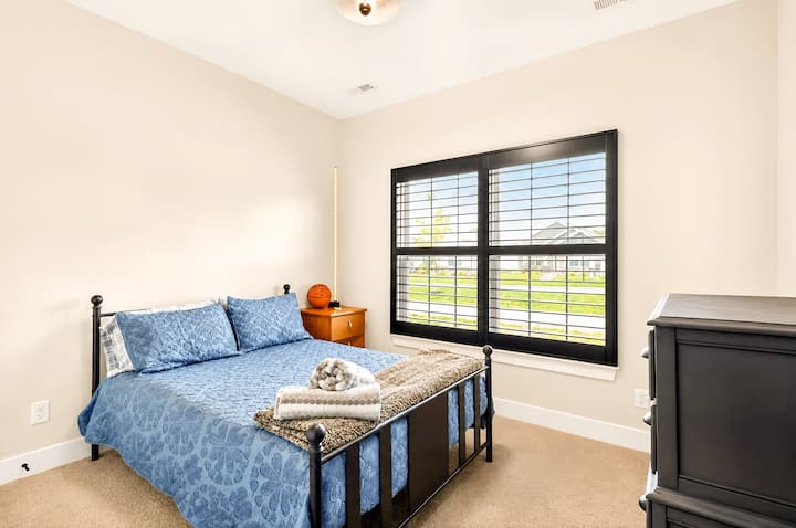 Dormitorio luminoso y acogedor con persianas elegantes y atractiva ropa de cama azul