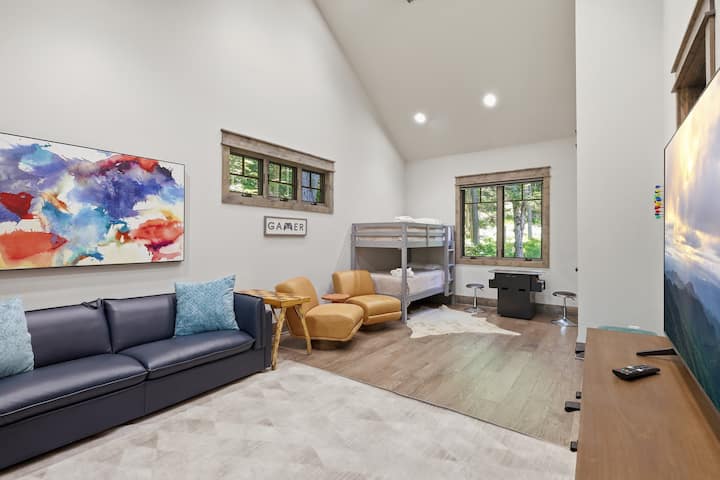 Luminosa habitación con literas estilo loft, zona de estar, TV y espacio para juegos