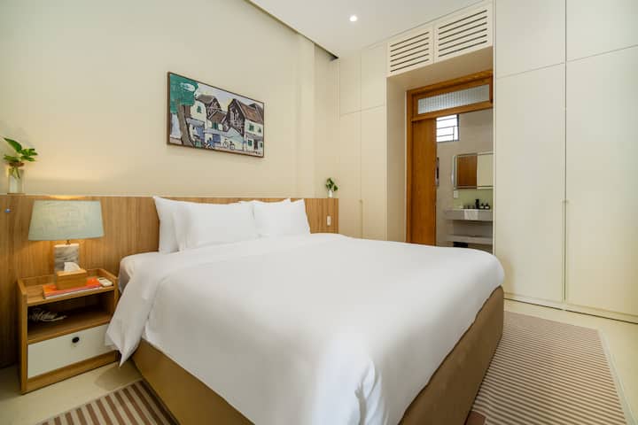 Phòng ngủ 1 thanh lịch với giường cỡ king, ga trải giường trắng tinh tươm, điều hòa và cửa sổ lớn. Một nơi nghỉ ngơi yên bình với tầm nhìn ra khu vườn nhiệt đới cho giấc ngủ ngon ban đêm.