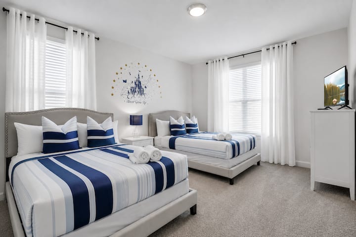 Recámara doble luminosa con cama queen y elegante decoración costera