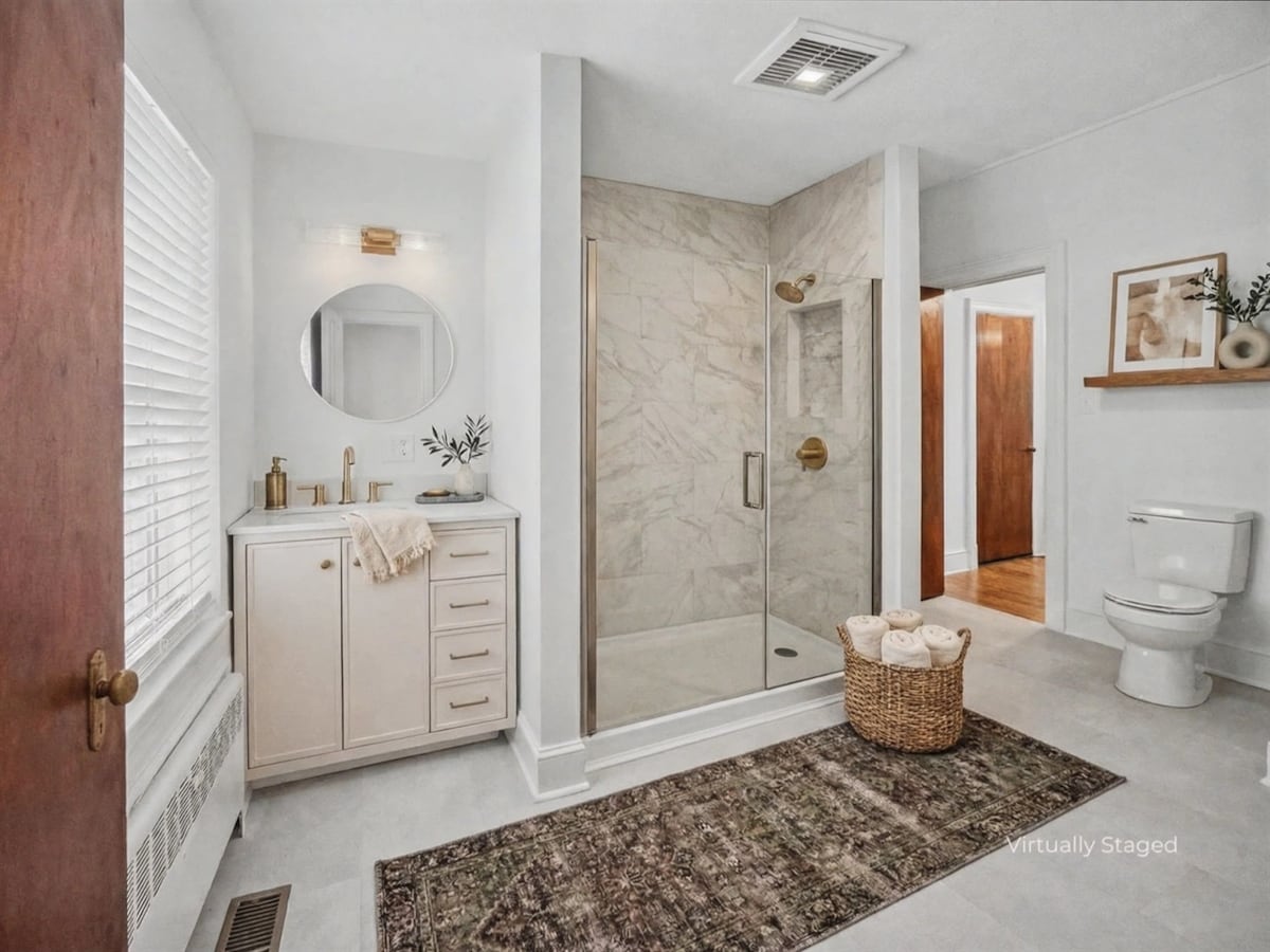 Primary bathroom walk-in shower with marble tile and brass fixtures