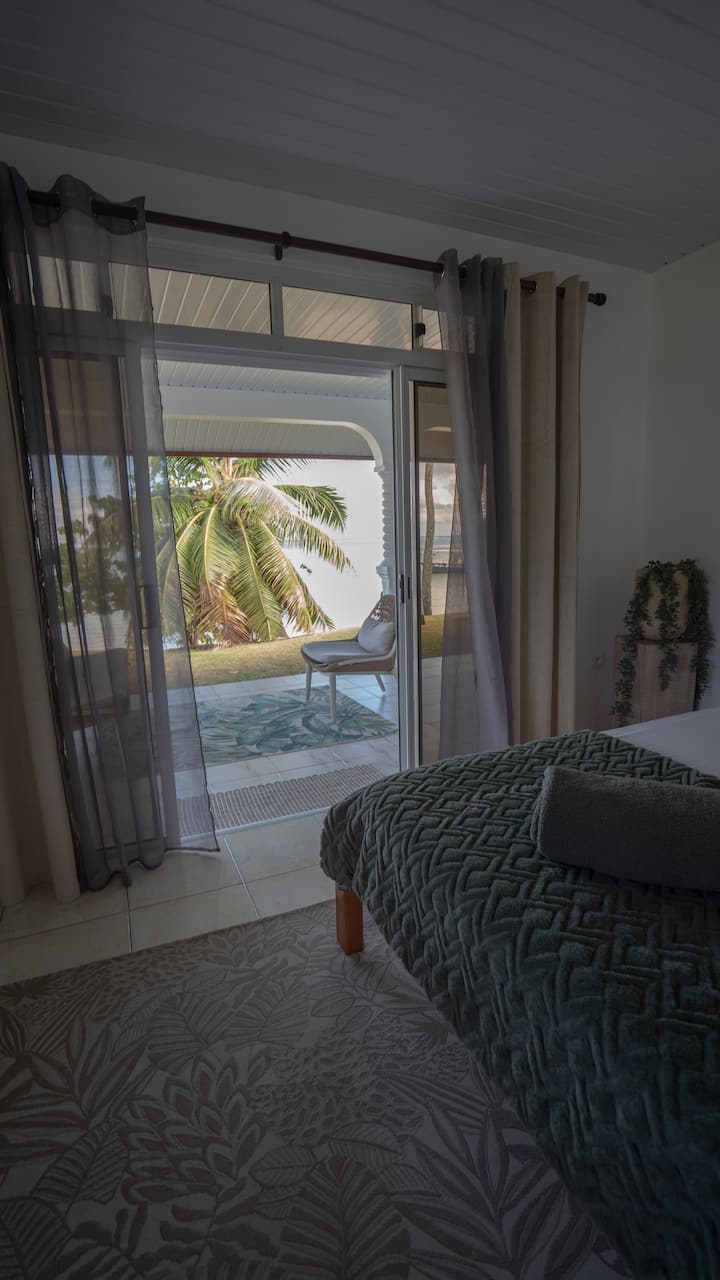 Master bedroom: wake up to the ocean view or enjoy a deep sleep with blackout curtains and air conditioning. This bedroom has a private master bathroom attached with a large shower, toilet, sink, and mirror.